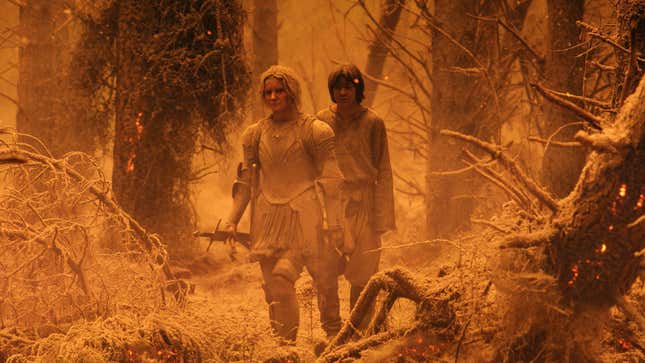 Galadriel and a kid walk through the charred landscape of Mordor.