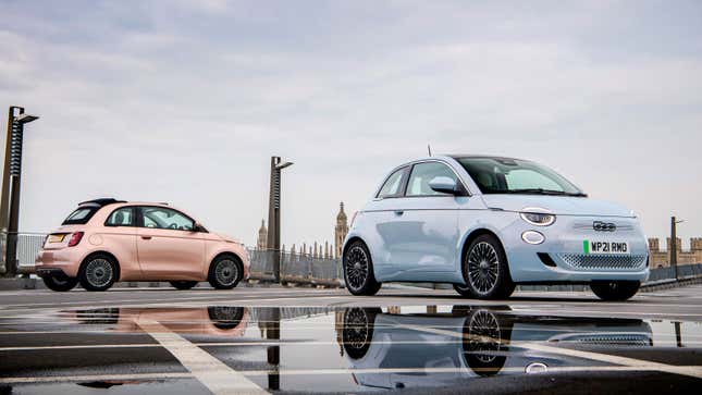 A photo of two electric Fiat 500 cars parked on a bridge. 