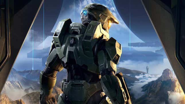 Halo's Master Chief stands with his back to the viewer, looking out over an alien world.
