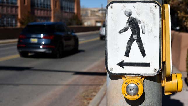 A photo of a crosswalk button at an intersection. 
