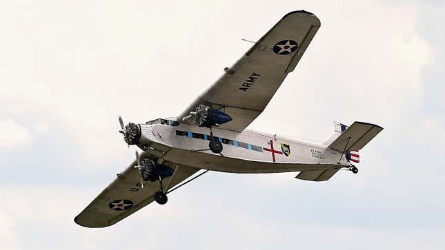 A photo of a Ford Trimotor plane flying in the air. 