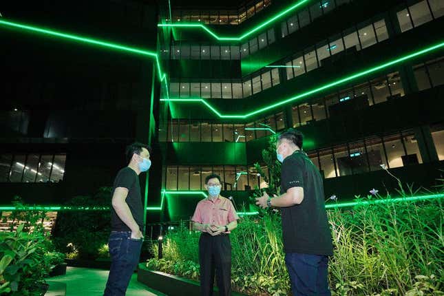 People stand in front of Razer's headquarters at night.