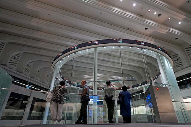 FILE - Visitors are seen in Tokyo Stock Exchange on Aug. 18, 2023 in Tokyo. Asian shares advanced Friday, with solid gains for Chinese markets after the central bank eased the reserve requirements for banks to encourage more lending and prop up the slowing economy. (AP Photo/Shuji Kajiyama, File)