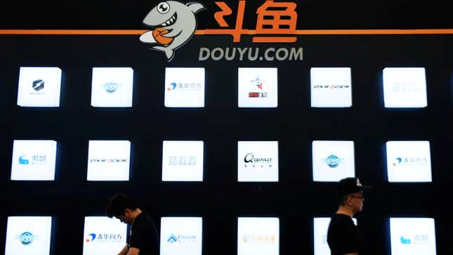 People walk past a booth of live-streaming platform Douyu at the ChinaJoy digital entertainment expo.