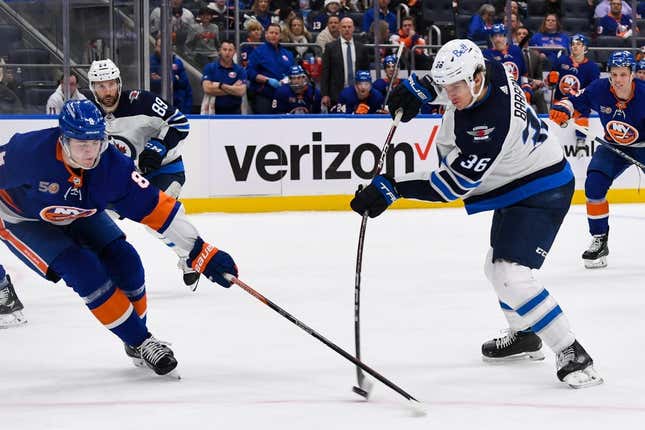 Feb 22, 2023; Elmont, New York, USA; Winnipeg Jets center Morgan Barron (36) attempts a shot defended by New York Islanders defenseman Noah Dobson (8) during the third period at UBS Arena.