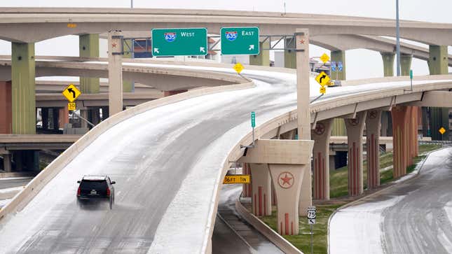 A driver slowly navigates through icy road conditions on the US 75 highway and LBJ 635 interchange Tuesday, Jan. 31, 2023, in Dallas.