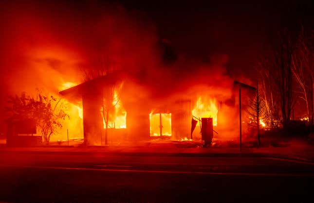 A structure burns as flames from the Dixie fire tear through downtown Greenville, California.