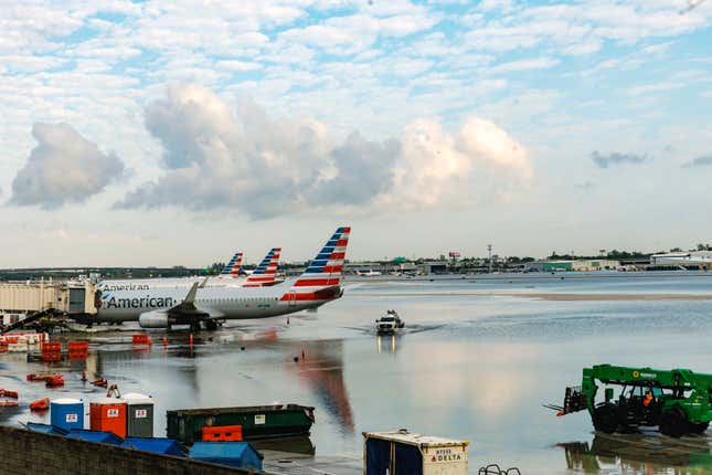 American Airlines airplanes sit at terminal as a truck drives through the flooded tarmac at the Fort Lauderdale-Hollywood International Airport on April 13, 2023, Fort Lauderdale, Florida. 