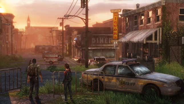 A screenshot from The Last of Us in which Joel and Ellie stand in a post-apocalyptic town looking toward a skyline at sunrise or sunset with a wrecked police car beside them.