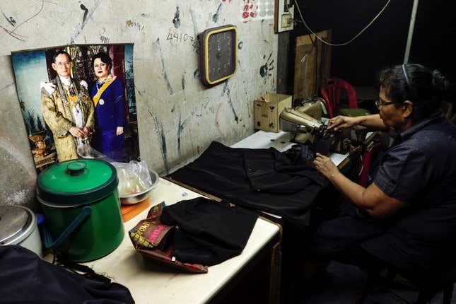 A tailor works on black clothes for customers mourning Thailand's late King Bhumibol Adulyadej at a market in Bangkok, Thailand, October 17, 2016. REUTERS/Athit Perawongmetha - RTX2P4Y0