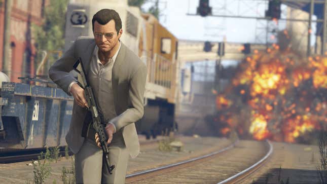 A GTA V screenshot depicting a white guy in a suit, running away from an explosion on some train tracks with an assault rifle in hand.