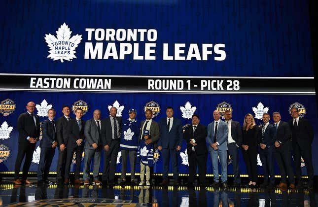 Jun 28, 2023; Nashville, Tennessee, USA; Toronto Maple Leafs draft pick Easton Cowan stands with Leafs staff after being selected with the twenty eighth pick in round one of the 2023 NHL Draft at Bridgestone Arena.