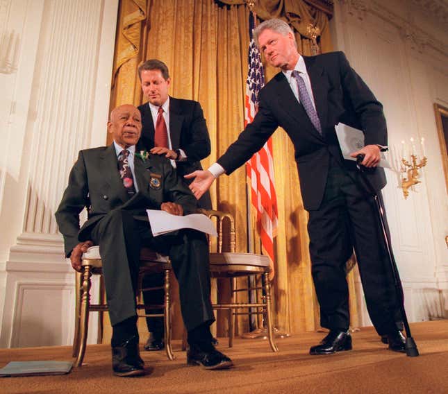  In this May 16, 1997, file photo, President Bill Clinton and Vice President Al Gore, background, help Herman Shaw, 94, a Tuskegee Syphilis Study victim, during a news conference in Washington.