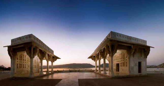 Ajmer Baradaris, 1636, Ana Sagar Lake: To fulfill a vow made as thanksgiving for a successful military campaign, Shah Jahan ordered the construction of a Jami (prayer hall) immediately behind Muin al-Din Chishti’s tomb. The white marble prayer hall has a 45-metre-long line of 11 arch-shaped openings, borne on slender pillars and sheltered by an angled chhajja (overhanging) below. The interiors are divided by slender pillars into 22 bays and have flat ceilings throughout, possibly to preempt architectural competition with the dome that rises above the saint’s mausoleum. The focal mihrab (niche) of the mosque has a part-octagonal recess with net vaulting above. Around 18 years later, Shah Jahan added an imposing arched gate that served as a monumental entrance to the dargah. Shah Jahan’s daughter Jahanara, another passionate disciple of the Ajmer saint, added the elegant marble entrance porch. Among Shah Jahan’s other contributions to Ajmer is a series of baradaris built beside Ana Sagar, the great artificial lake on the outskirts of the city. These pavilions occupy the site of a garden residence laid out by Jahangir. Shah Jahan’s white marble baradaris have pillared verandas sheltered by angled chhajjas. The verandas lead to flat-ceilinged rectangular chambers, one of which has a balcony looking out over the lake.