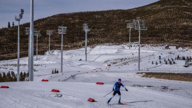 An athlete from Team France passes snowless hills as he takes part in a training session Zhangjiakou National Biathlon Centre on February 7, 2022 in Zhangjiakou, China. The Beijing 2022 Winter Olympics are held entirely on artificial snow. 