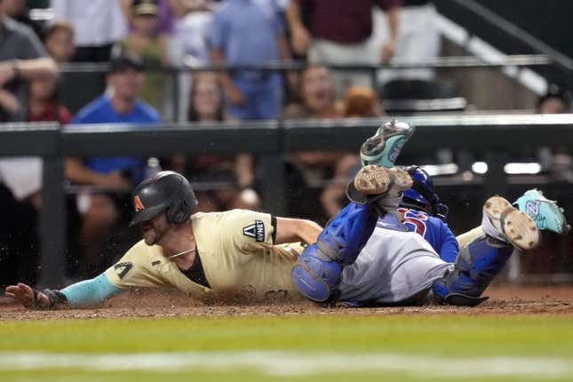 Sep 16, 2023; Phoenix, Arizona, USA; Arizona Diamondbacks pinch hitter Evan Longoria (3) slides at home and beats the tag of Chicago Cubs catcher Yan Gomes (15) to score the game winning run during the 13th inning at Chase Field.