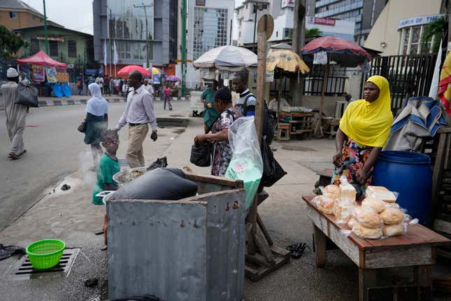 A woman sells bread on the streets of Lagos, Nigeria, Tuesday Sept. 5, 2023. (AP Photo/Sunday Alamba)