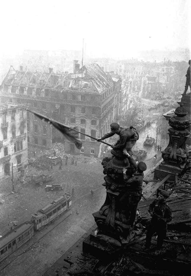 In this May 2, 1945 file photo, Soviet soldiers hoist the red flag over the Reichstag in Berlin. It's one of the iconic images of World War II: Soviet soldiers hoisting a red flag on top of the Reichstag after the fall of Berlin. What most people don't realize, however, is that the photograph isn't capturing the historical moment. Yevgeni Khaldei staged the scene on May 2, 1945 _ three days after the Soviets had captured the key seat of Nazi power.