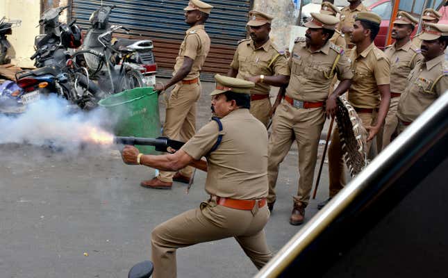 A police officer fires tear gas to disperse protestors in Chennai on Jan.23,