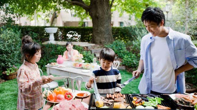 Father cooking on outdoor grill with children