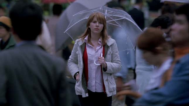 A screenshot from Lost in Translation showing Scarlet Johansson holding an umbrella and walking through a crowded intersection in Japan