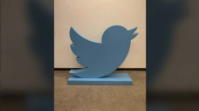 A photo of the blue bird Twitter statue that sold for $100,000 is shown on the floor.