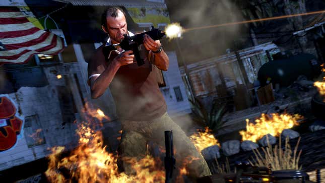 Grand Theft Auto V protagonist Trevor fires an assault rifle while standing amidst flaming wreckage.
