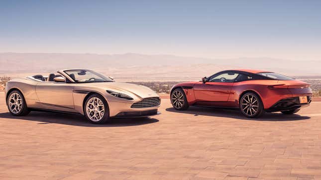 A photo of two Aston Martin DB11s parked overlooking mountains. 