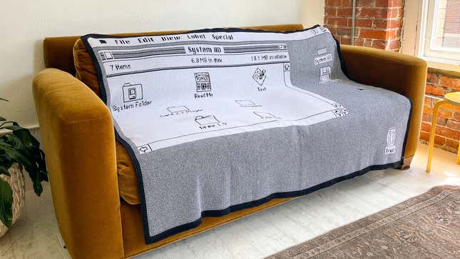 Throwboy's classic knitted cotton throw draped over a couch in an apartment.