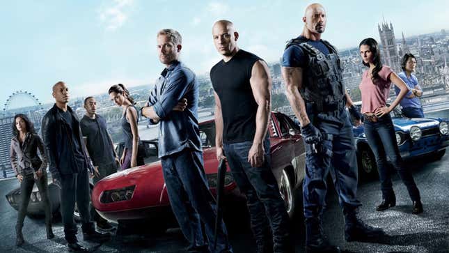 The cast of Fast and Furious stand stoically around three exotic cars.