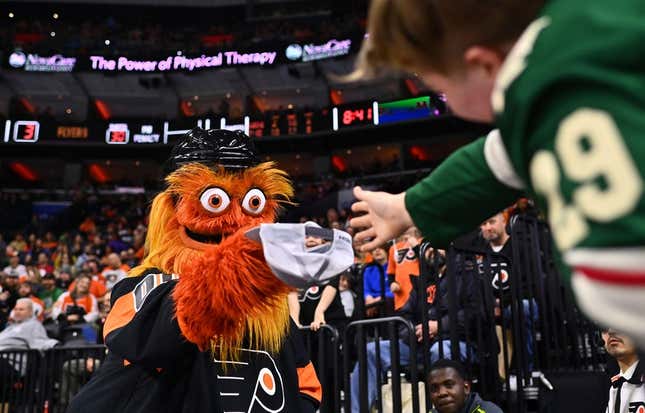 Mar 23, 2023; Philadelphia, Pennsylvania, USA; Philadelphia Flyers mascot Gritty taunts a Minnesota wild fan at Wells Fargo Center.
