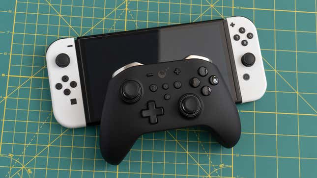 Photo of a GuliKit KingKong Pro 2 controller and a Nintendo Switch OLED