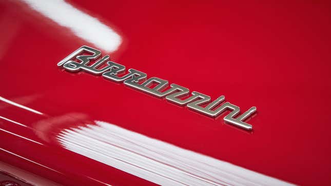A close up photo of the chrome Bizzarrini logo on the red bodywork.