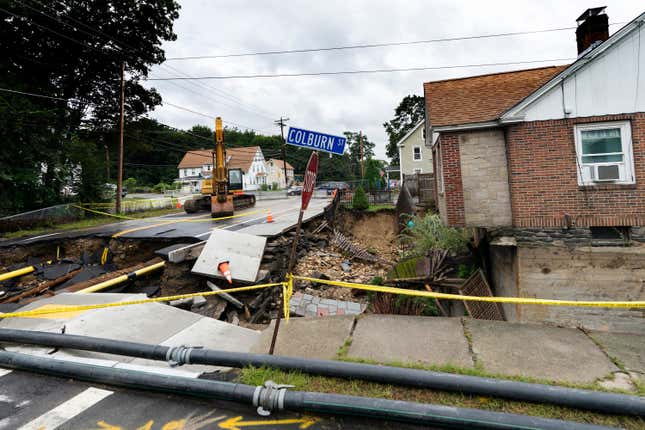 La cinta de precaución de la policía está extendida frente a una casa donde el patio delantero y la carretera fueron arrasados   por una inundación reciente, el 13 de septiembre , 2023, en Leominster, Massachusetts. 