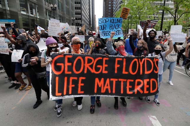 Protesters hold signs as they march during a protest over the death of George Floyd in Chicago on May 30, 2020. 