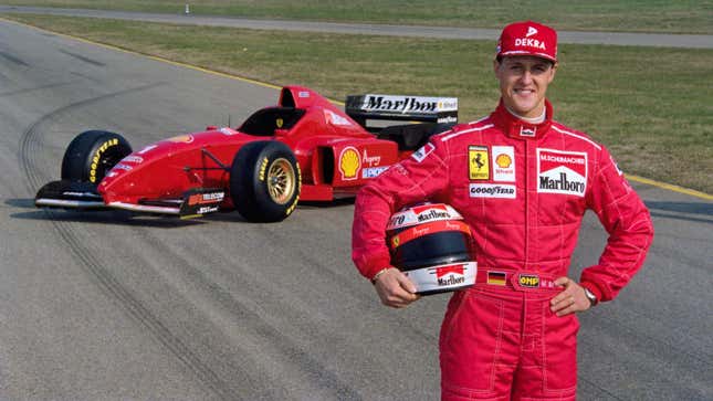 Michael Schumacher stands in front of the 1996 Ferrari F1 car.