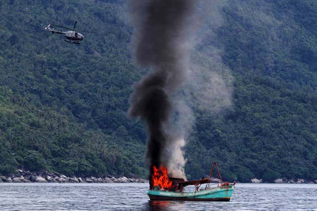 An unmanned Vietnamese fishing boat is blown up and sunk by the Indonesian navy,