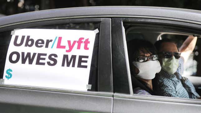  A driver and passenger wear face masks as Uber and Lyft drivers with Rideshare Drivers United and the  Transport Workers Union of America conduct a ‘caravan protest’ outside the California Labor Commissioner’s office amidst the coronavirus pandemic on April 16, 2020 in Los Angeles, California.