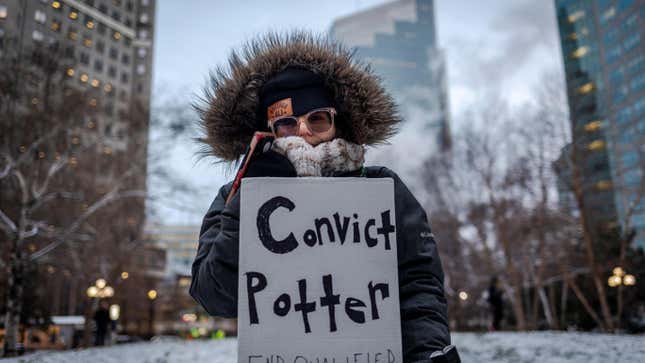 A protester holds a sign reading “Convict Potter, End Qualified Immunity” outside the Hennepin County Government Center as the trial of former Brooklyn Center police officer Kim Potter begins on December 8, 2021, in Minneapolis, Minnesota. - Wright, 20, was shot and killed during a traffic stop in the Minneapolis suburb of Brooklyn Center on April 11 by Potter, who reportedly confused her handgun for her taser.