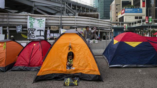 An Occupy Central protester looks her phone in her tent at a protest site in Admiralty near the government headquarters in Hong Kong October 16