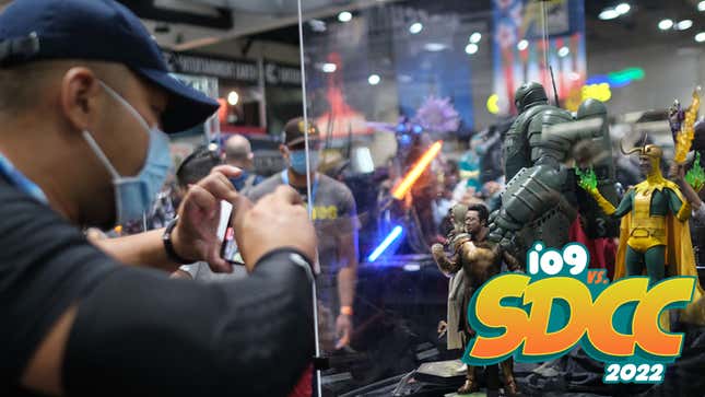 An attendee films collectible statues of characters from the Marvel universe in a display during San Diego Comic-Con International in San Diego, California, on July 24, 2022. 