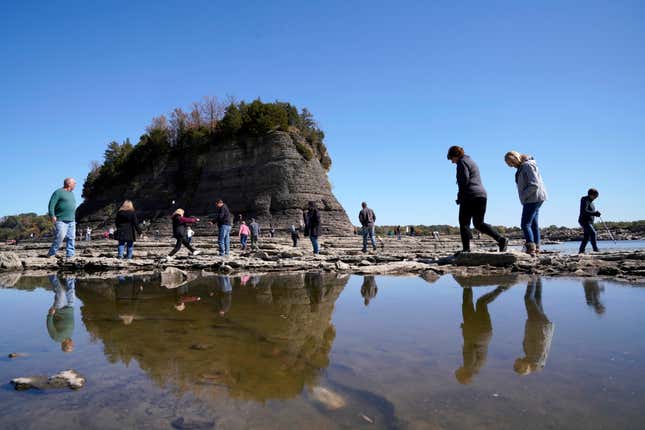 People walk to Tower Rock, an attraction normally surrounded by the Mississippi River and only accessible by boat, Oct. 19, 2022, in Perry County, Mo.