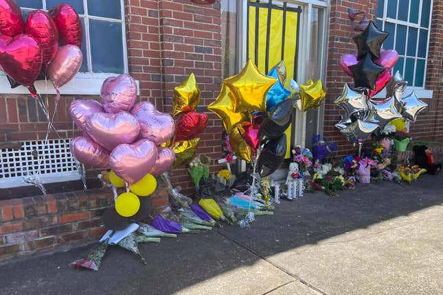 Flowers and balloons sit piled outside the Mahogany Masterpiece dance studio on Wednesday, April 19, 2023, in Dadeville, Ala. 