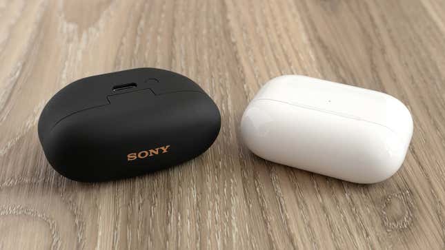 The Sony WF-1000XM5 in their charging case next to the Apple AirPods Pro 2 in their charging case.