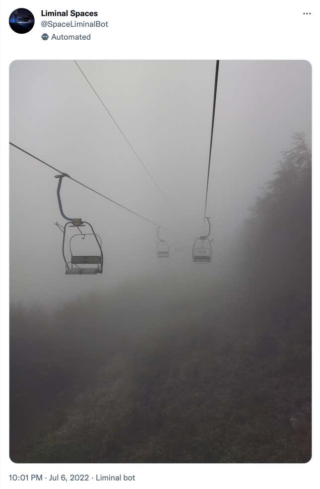 A picture of a point on a ski lift surrounded by fog. 