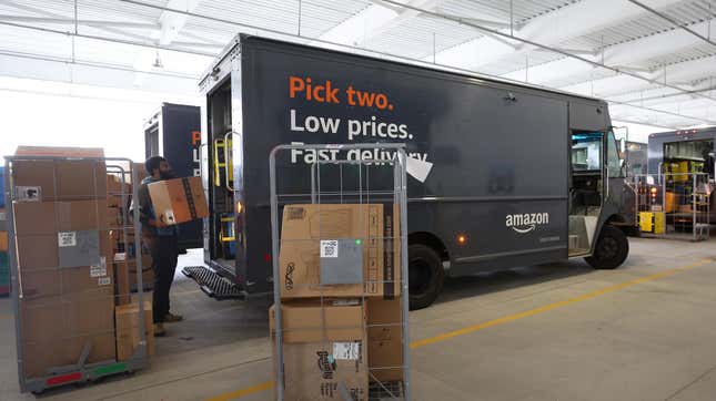 A man loads a Amazon delivery truck, one that contains an AI system that tracks drivers' every move.