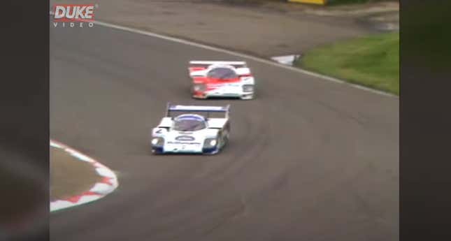 A Porsche 956 race car leads a Lancia at Silverstone in the 1980s