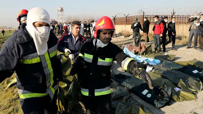 Rescue workers carry the body of a victim of an Ukrainian plane crash in Shahedshahr, southwest of the capital Tehran, Iran on January 8, 2020.