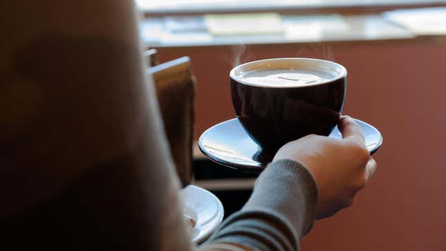 A customer carries a cup of coffee to her table at Colson Patisserie on February 22, 2016 in Brooklyn, New York City.