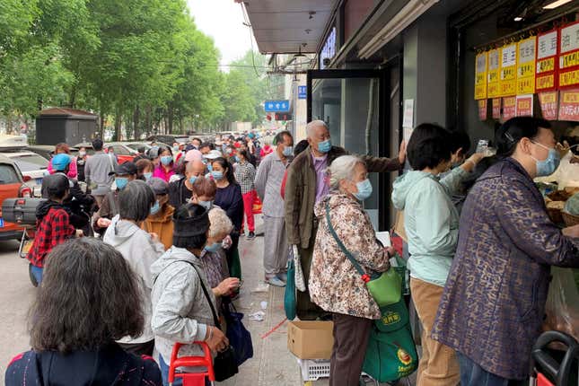 Residents wearing face masks line up to get food supplies from a grocery store following the coronavirus disease (COVID-19) outbreak in Chaoyang district of Beijing, China April 25, 2022. 